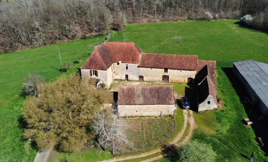 En Périgord Noir, à proximité d'un des plus beaux villages de la Vallée de la Vézère, magnifique ancien corps de ferme et ses nombreuses dépendances, à rénover, sur environ 1,5 hectare de